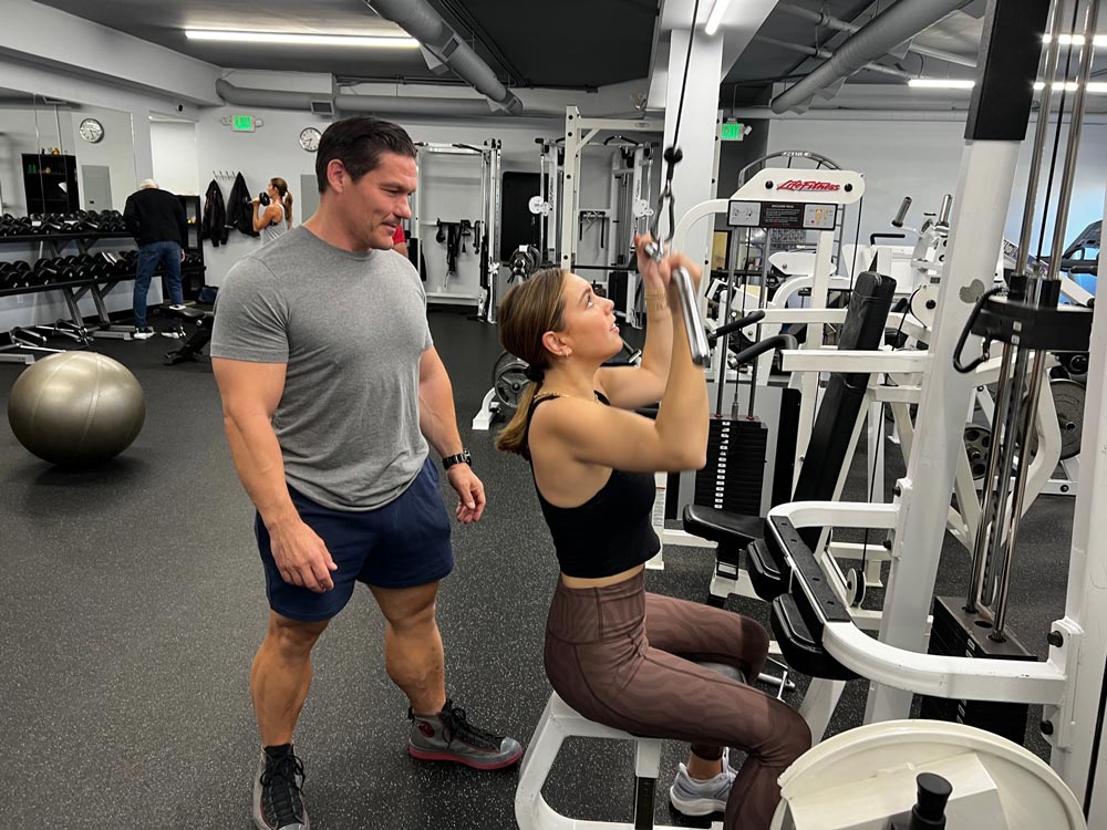 owner Michael Shenkman helps a client train at Trident Fitness